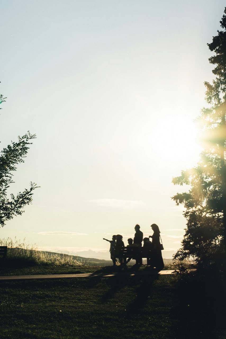 A family on a hilltop at sunset